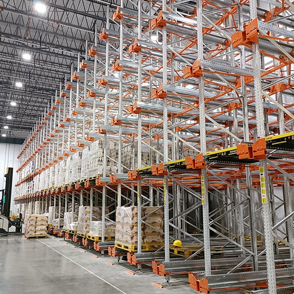 How does the pallet shuttle system store and pick up goods?